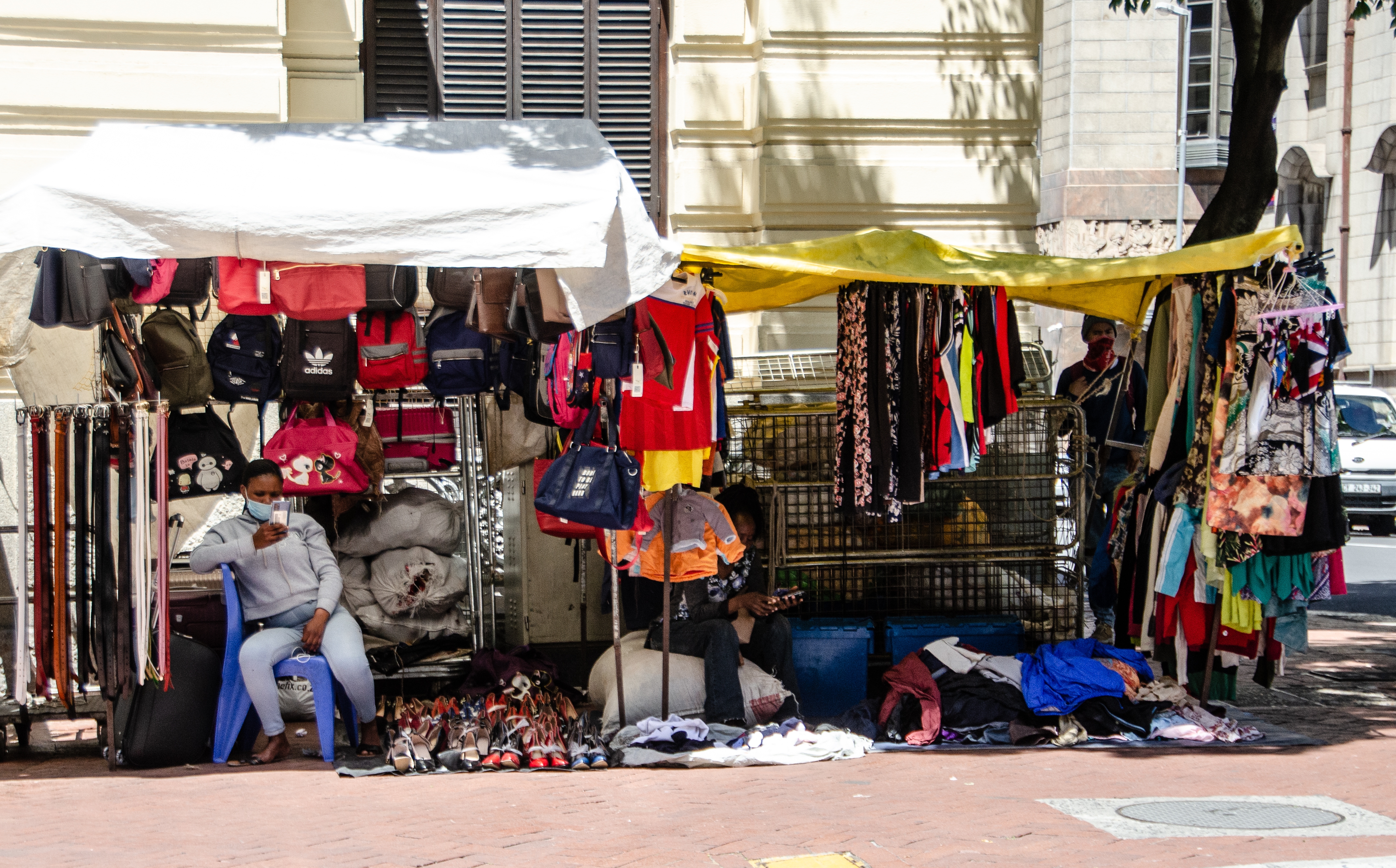 Eine informelle Händlerin bietet ihre Waren auf einem Gehweg in Kapstadt an.