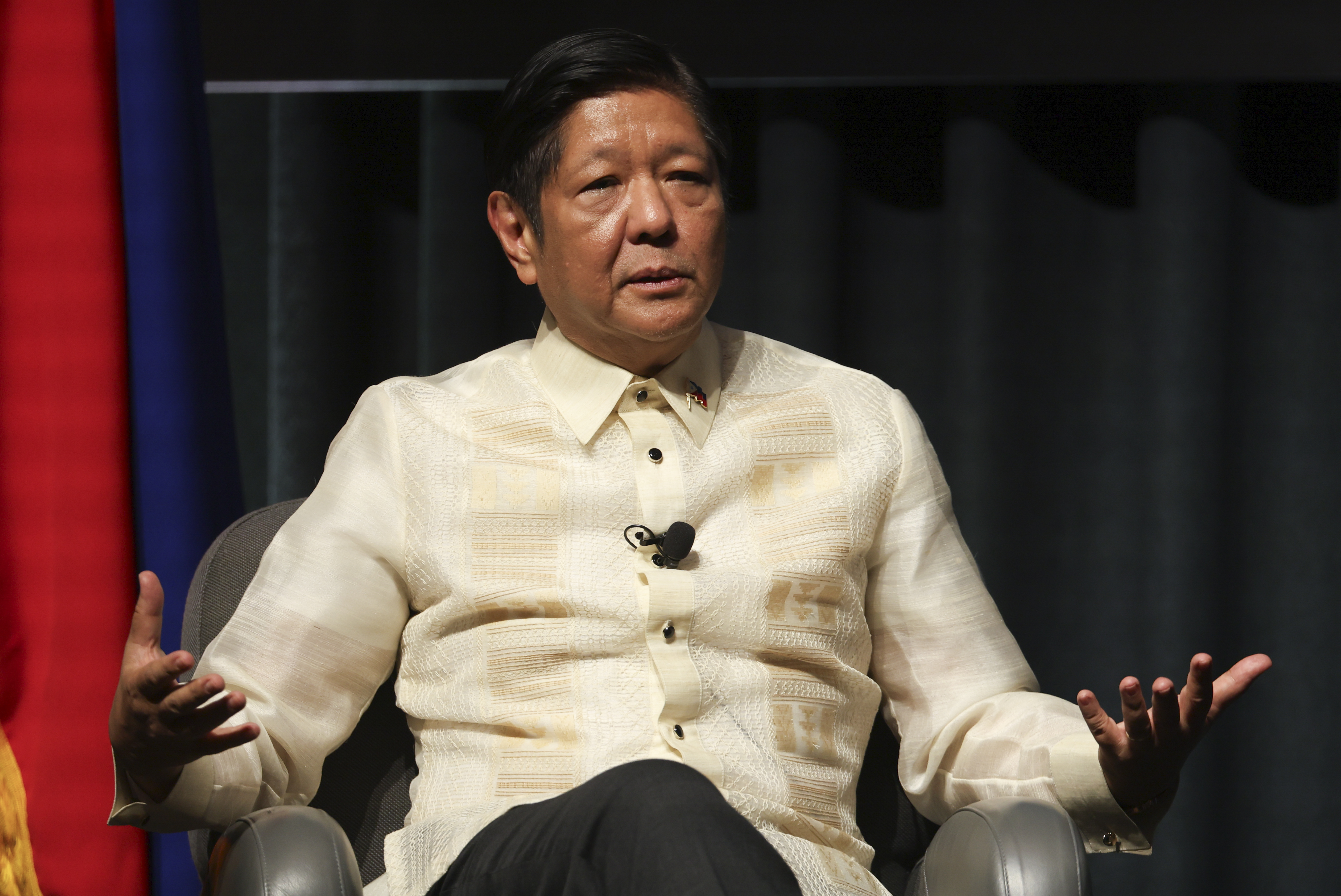 Auf dem Foto sitzt der philippinische Präsident Marcos Jr. in einer Diskussionshaltung.  