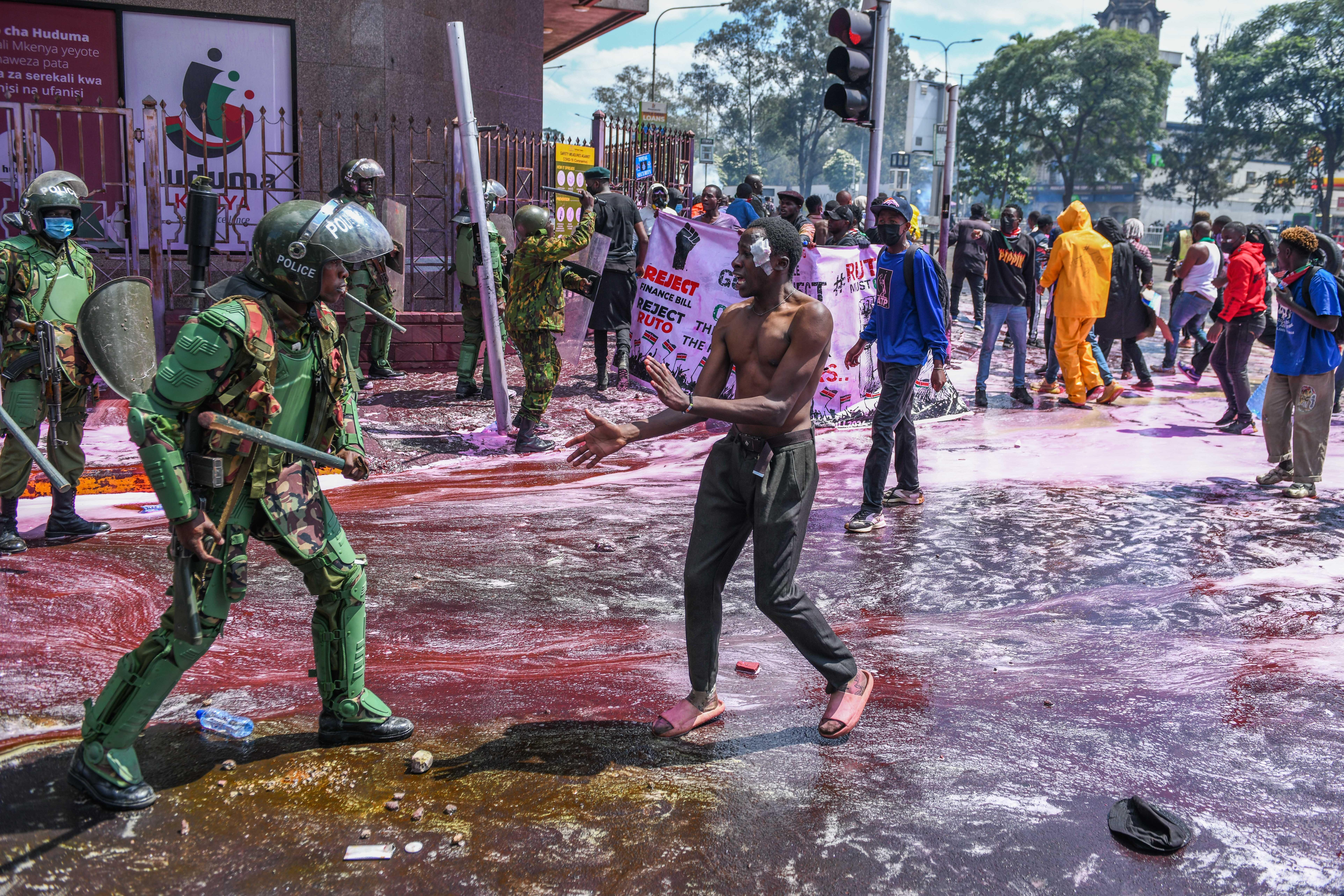 Kenianische Polizisten gehen in Nairobi gegen Demonstranten vor, die gegen die Steuererhöhungen im geplanten "Finanzgesetz 2024" protestieren