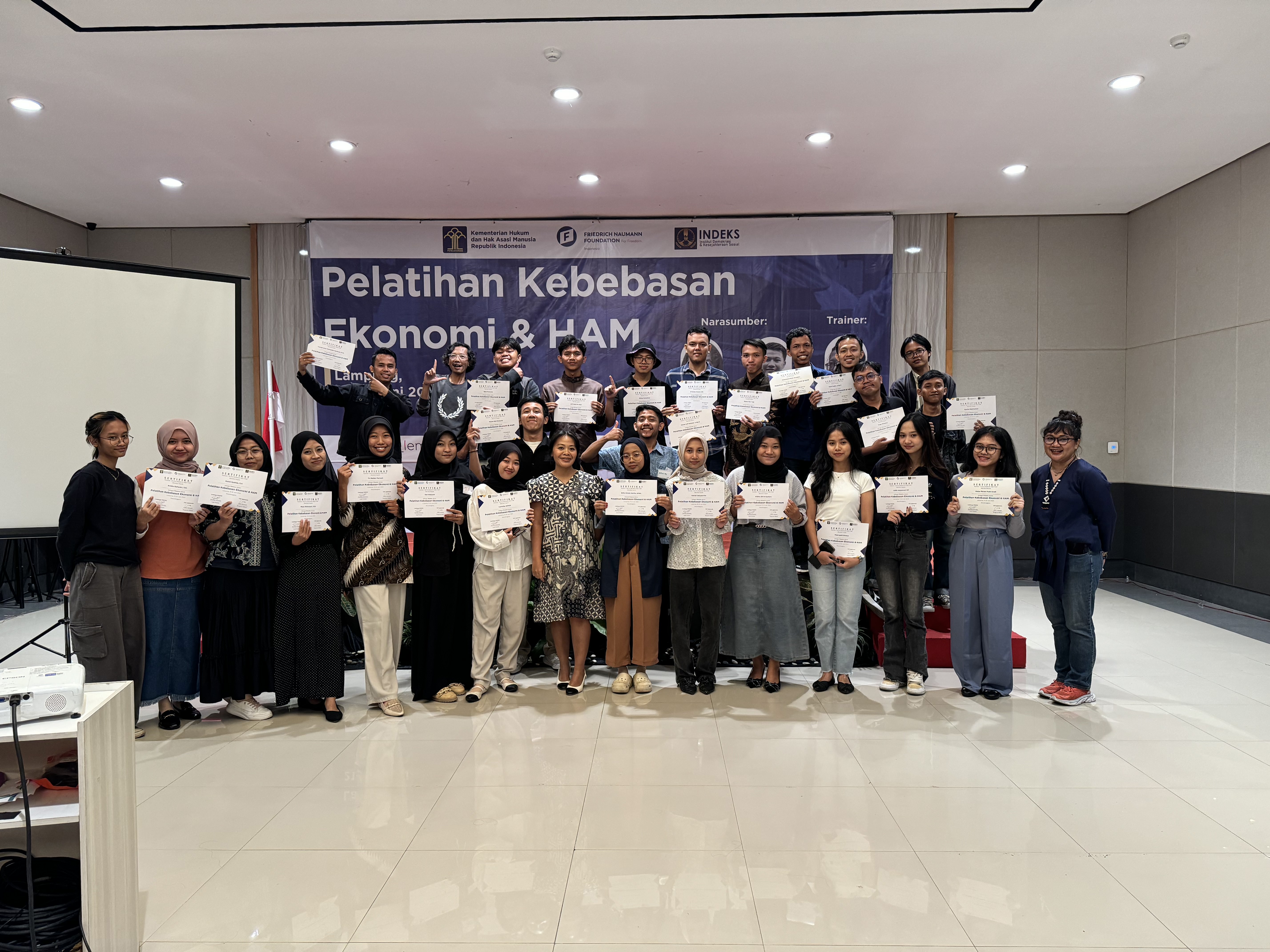 Participants of the event standing alongside Ganes Woro Retnani, Program Officer of FNF Indonesia, in front of a banner showing the event's details.