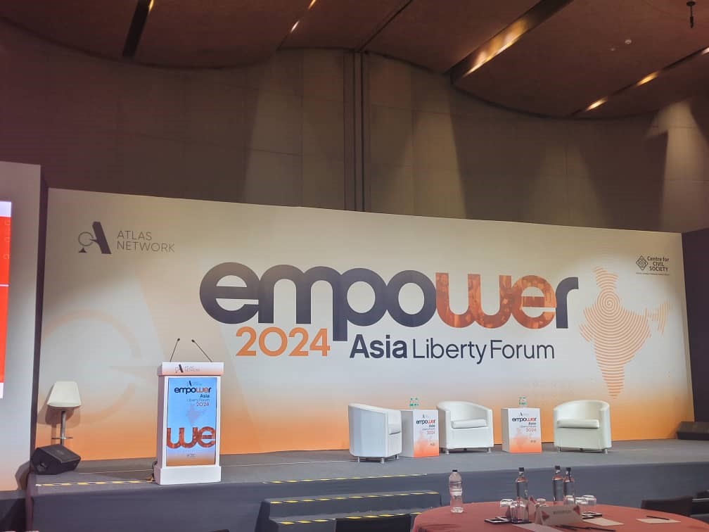 A view of the Asia Liberty Forum 2024's stage. A podium is seen standing a few metres apart from three single seats reserved for speakers.