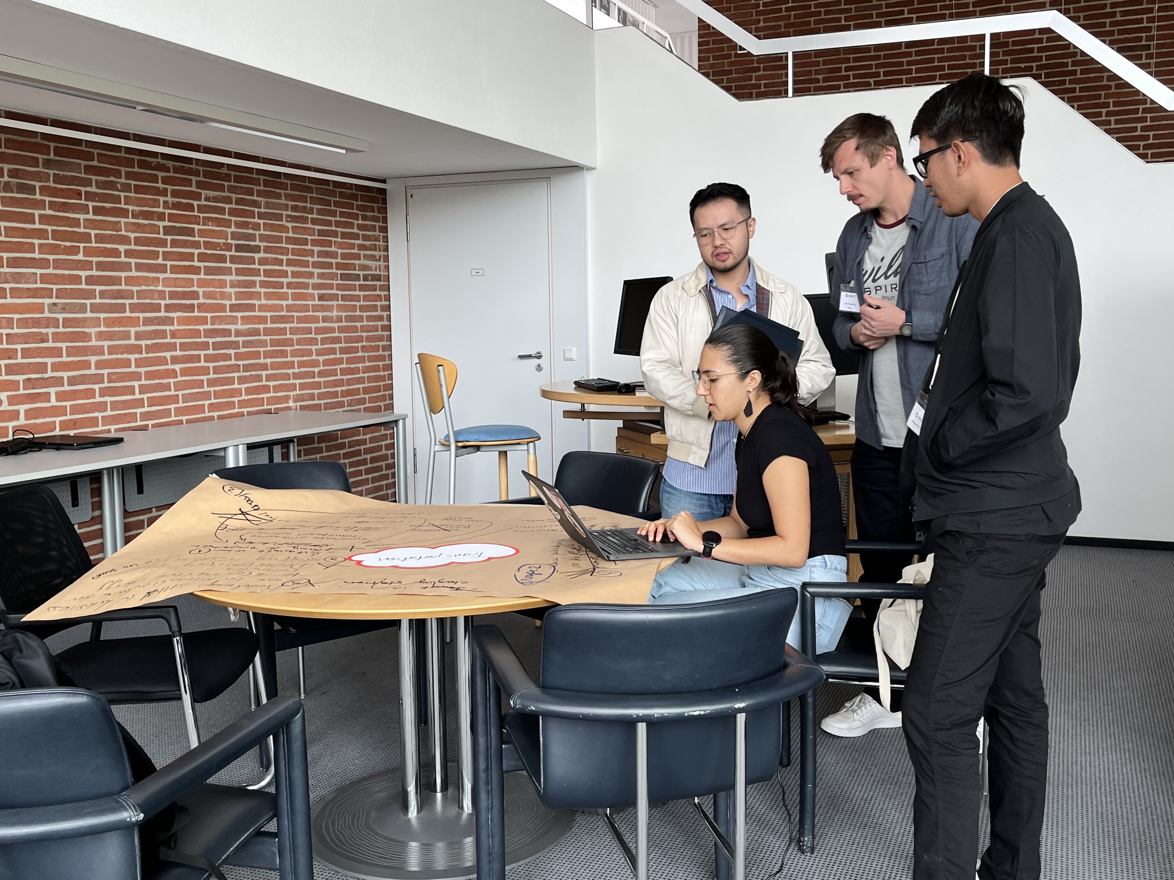 Hans Jong (man with glasses; far left) were seen with the other seminar participants. They were looking at something displayed on a participant's laptop.