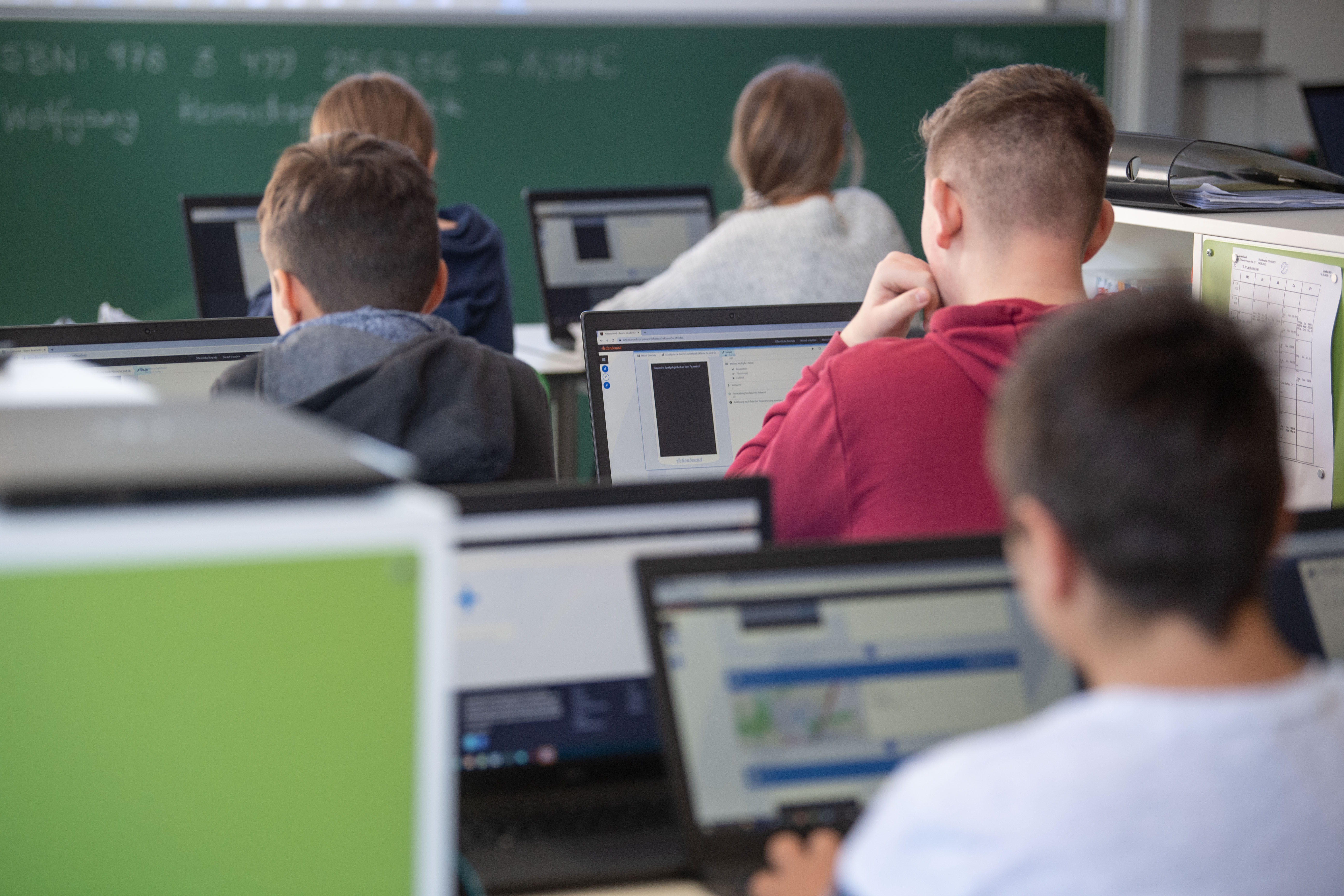 Schülerinnen und Schüler nehmen im Klassenzimmer einer 9. Klasse der Gemeinschaftsschule Leutenbach am Geografieunterricht mit Hilfe von Laptops und Tablets teil. 