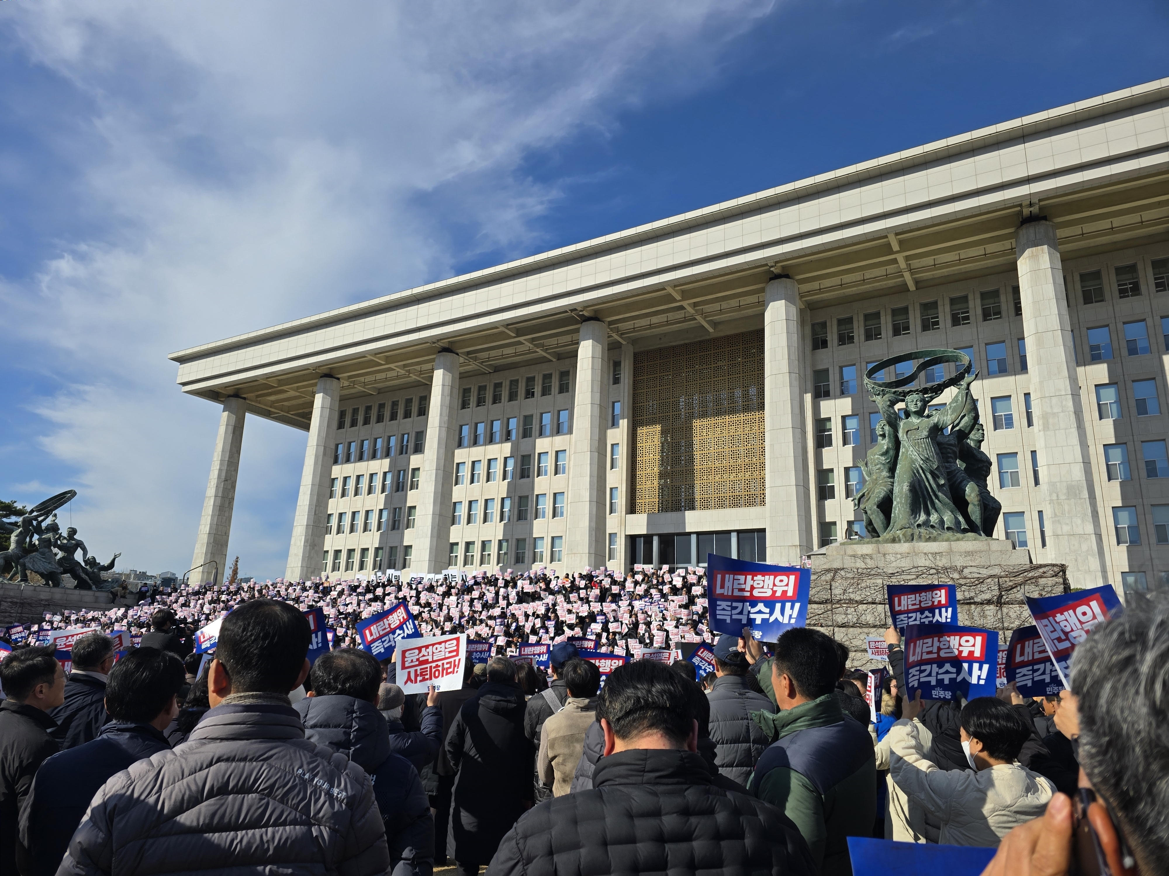 Menschen, die sich vor dem Gebäude der Nationalversammlung versammelt haben, protestieren nach der Verhängung des Kriegsrechts in Seoul, Südkorea, am 04. Dezember 2024