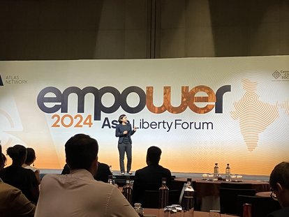 A woman, most likely one of the presenters, was seen standing on a stage. The banner of Asia Liberty Forum 2024 spanned behind her.