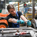 In der Werkstatt der ViP Verkehrsbetrieb Potsdam GmbH arbeitet der Auszubildende Tom Zobel im 2. Lehrjahr im Rahmen seiner Ausbildung am Fahrwerk einer Straßenbahn.