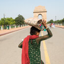 New Delhi, India, a girl carrying drinkable water bottles on her head during summer near India Gate