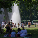 Zahlreiche Menschen suchen bei hochsommerlichen Temperaturen den kühlenden Springbrunnen im Treptower Park auf.