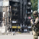 Ein Mitglied des ukrainischen Militärs steht vor beschädigten Gebäuden im Kiewer Stadtteil Borodyanka