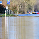 Zwei Autos stehen auf einer von dem über die Ufer getretenen Fluss Leine überfluteten Straße zwischen Hannover und Hemmingen in der Region Hannover. 