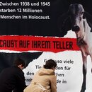 Mitglieder der internationalen Tierrechtsorganisation Peta befestigen ein Poster, das einen abgemagerten jüdischen Gefangenen in einem Konzentrationslager sowie ein kurz vor dem Tod stehendes Kalb zeigt.  Mitglieder der internationalen Tierrechtsorganisation Peta befestigen ein Poster, das einen abgemagerten jüdischen Gefangenen in einem Konzentrationslager sowie ein kurz vor dem Tod stehendes Kalb zeigt.