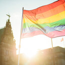 Eine Regenbogenfahne ist während einer Aktion zum Internationalen Tag gegen Homophobie auf dem Rathausmarkt der Hansestadt Hamburg im Gegenlicht zu sehen. 