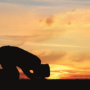 Mensch beim Gebet im Sonnenuntergang