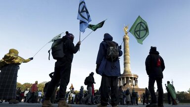 Supporters of the 'Extinction Rebellion' movement block a road at the Victory Column in Berlin, Germany, Monday, Oct. 7, 2019. The activists want to draw attention on the climate protest by blocking roads and with other acts of civil disobedience in Berlin and other cities around the world. 