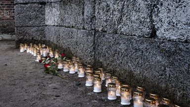 Kerzen und Kränze von Überlebenden des Konzentrationslagers Auschwitz stehen an der sogenannten „Todesmauer“ auf dem Gelände des ehemaligen Konzentrationslagers Auschwitz I anlässlich des 80. Jahrestages der Befreiung des Lagers am 27. Januar 2025 in Oswiecim, Polen. T